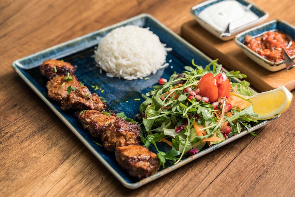 Grilled meat skewers on slate